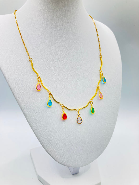 Gold necklace with colorful teardrop-shaped pendants on a mannequin bust.